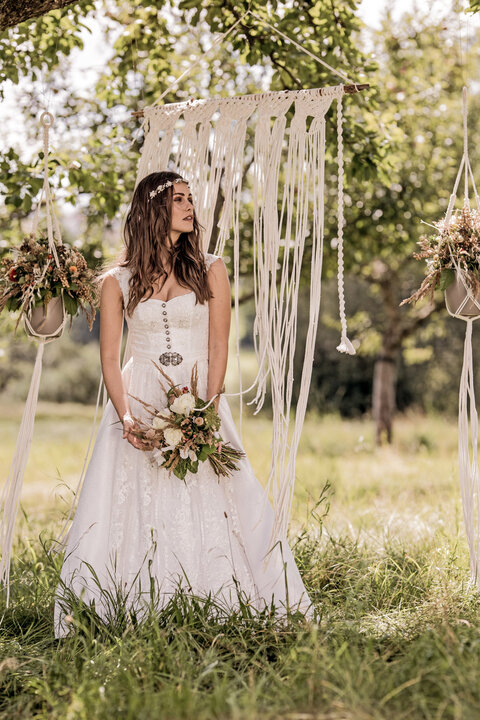langes Brautdirndl mit tollen Details sind perfekt für Trachtenhochzeiten im Boho Look.